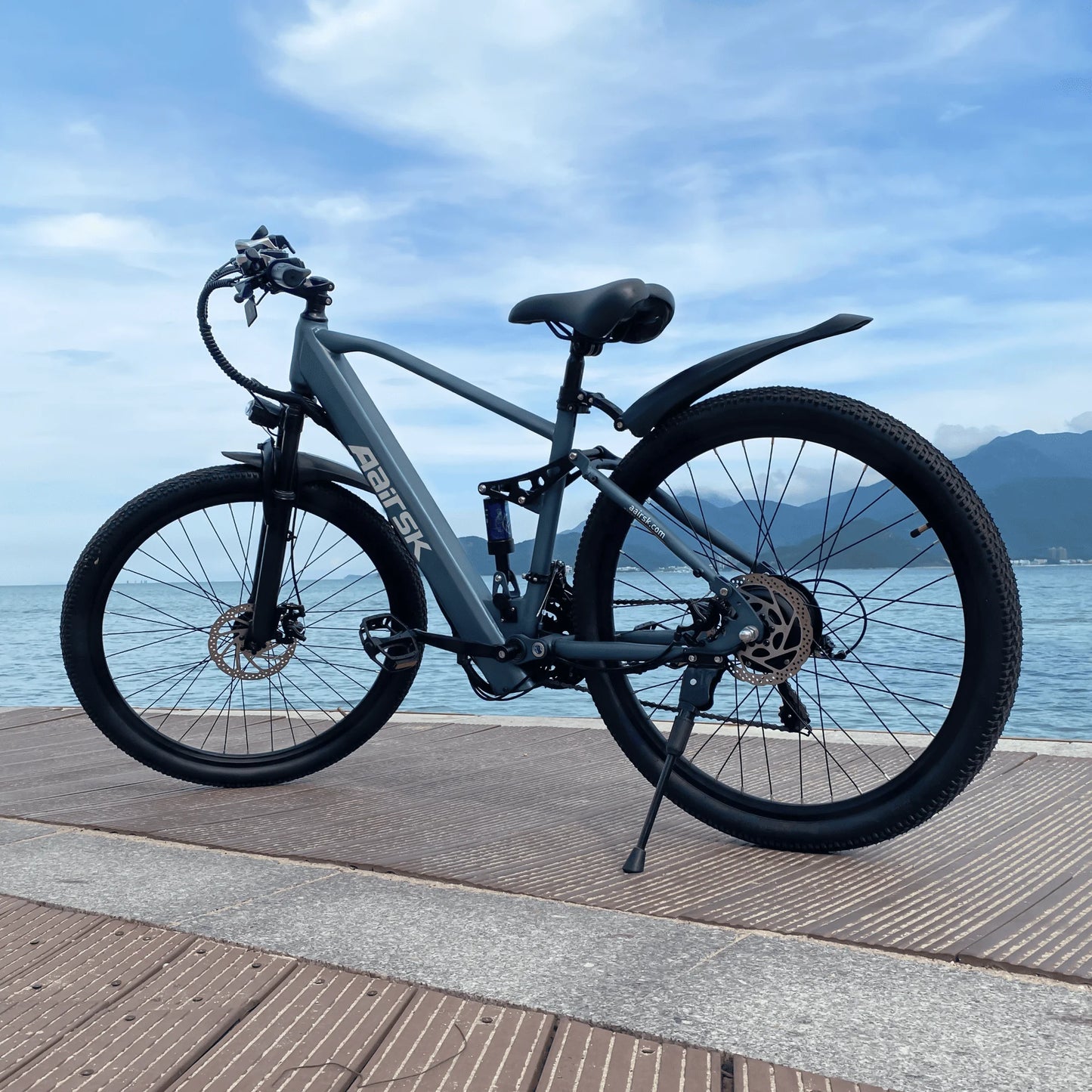Electric bike on a wooden platform with water and mountains in the background