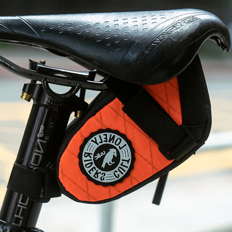 Bicycle seat with orange bag featuring a logo on a blurred background