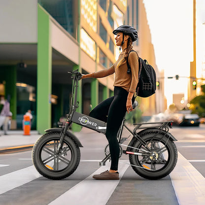 Woman riding IDOTATA 1000W Electric Bike 48V 20AH on city street, showcasing its folding design and fat tires.